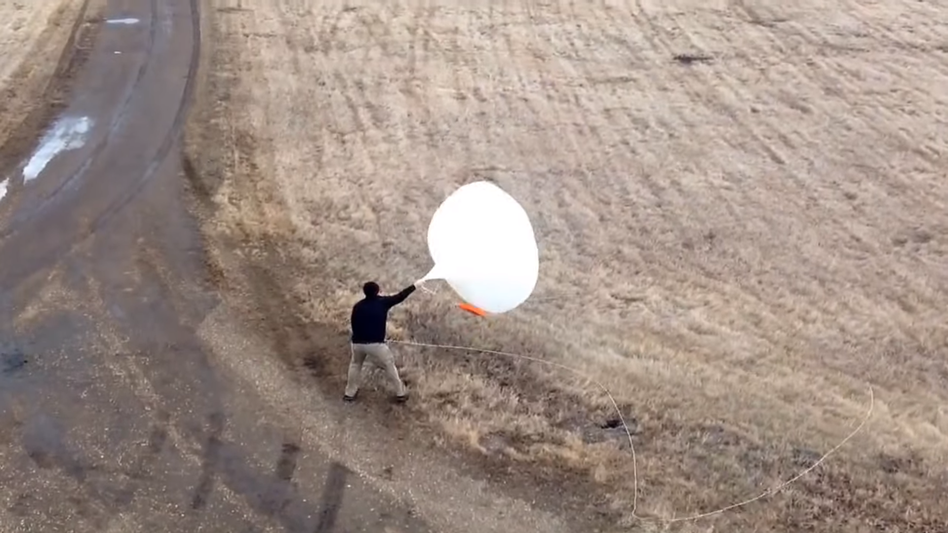 In very windy conditions, Forecaster Michael Matthews launches a weather balloon from the Weather Forecast Office in Bismarck, North Dakota. 