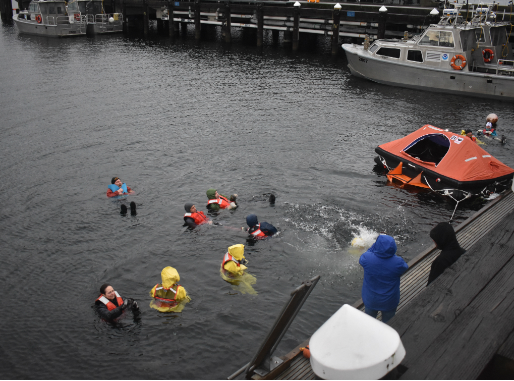 Arctic survival trainees jumped into the 48-degree waters of Seattle’s Lake Washington wearing just their street clothes and a flotation device in order to mimic an accident. (December 2019 photo).