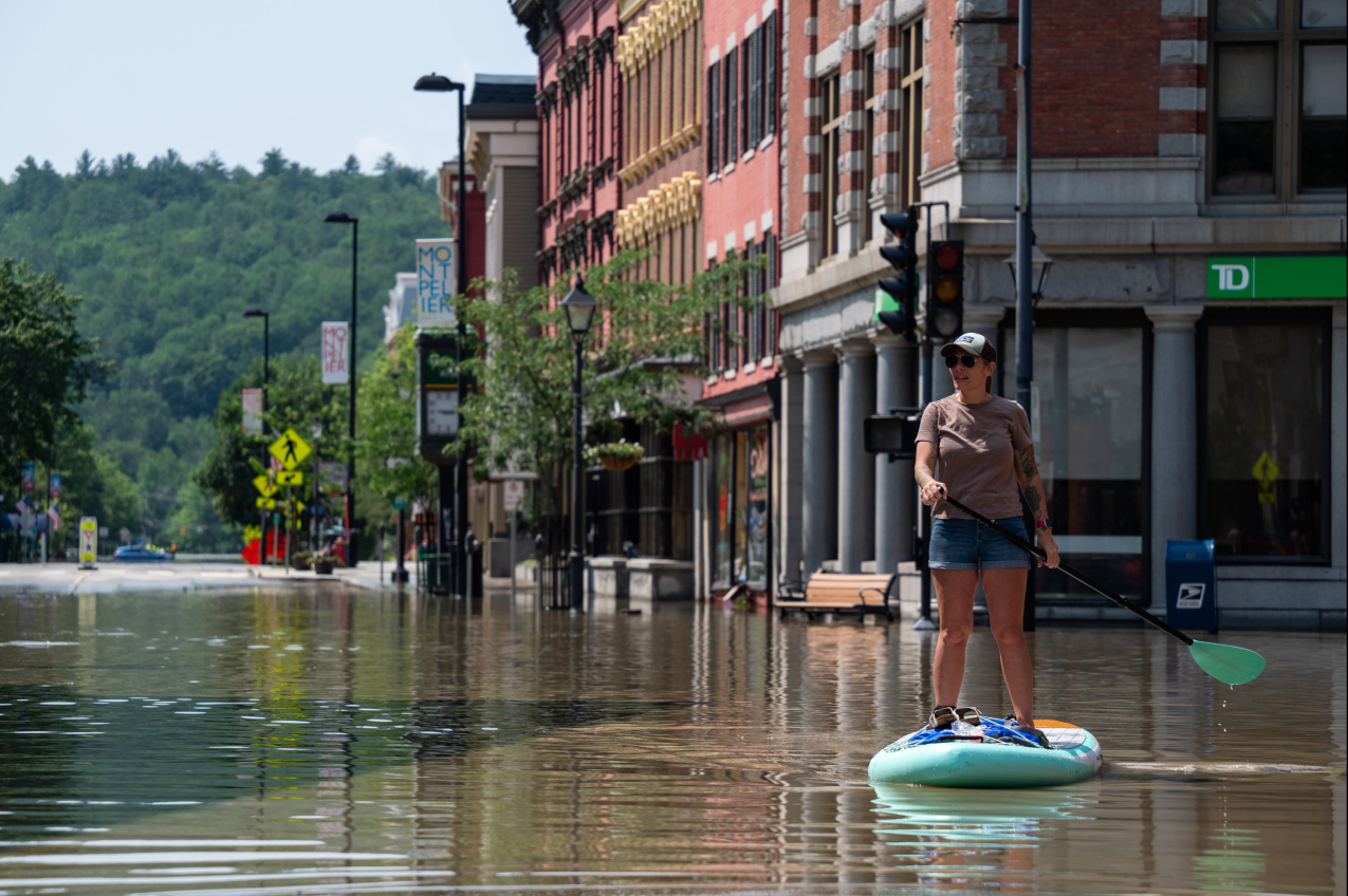 Montpelier resident Lynnea Timpone paddle boards at the intersection of Main Street and East State Street on July 11, 2023, in Montpelier, Vermont. Up to 8 inches of rain fell over 48 hours, causing catastrophic flooding in the area. 