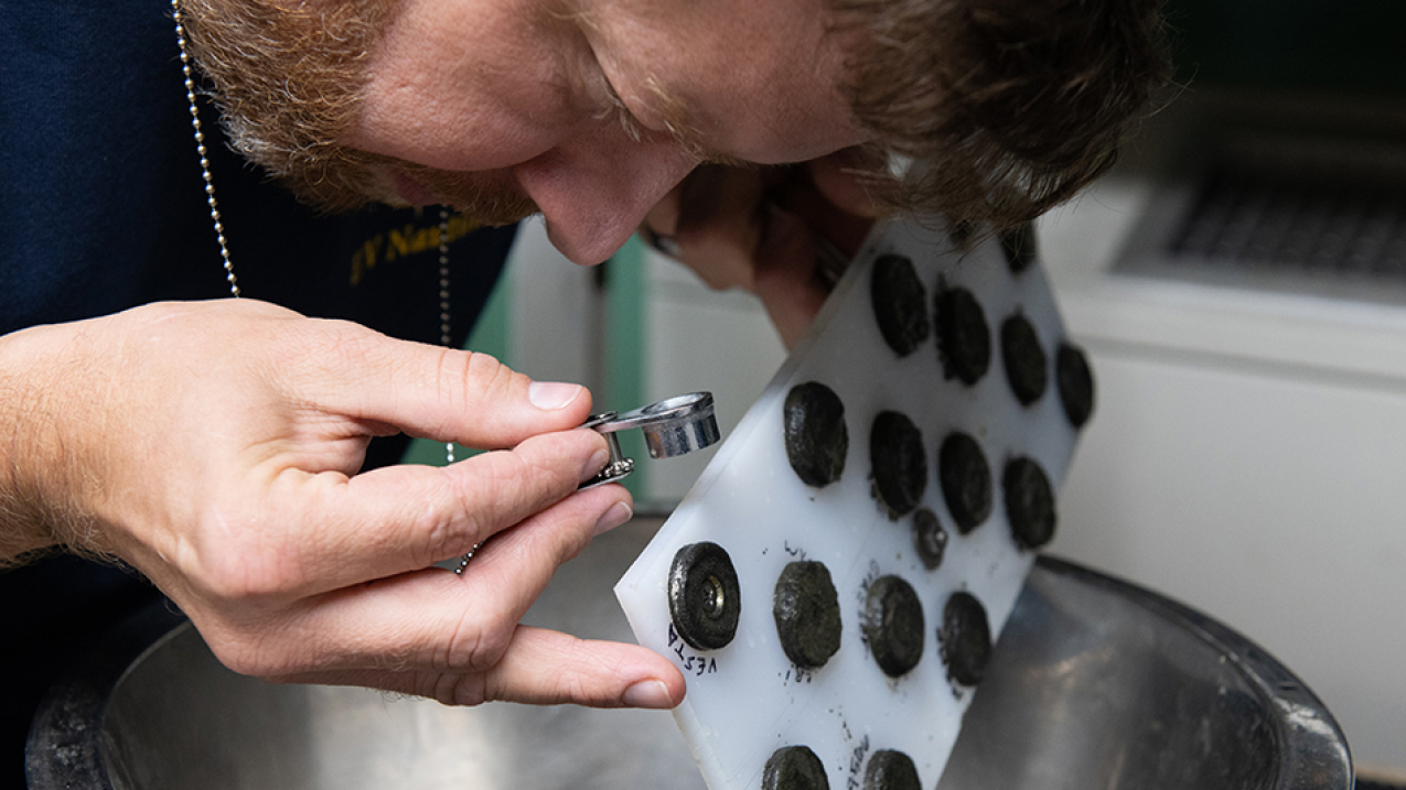 NASA scientist Dr. Marc Fries examines early samples attached to a magnetic board suspected to be fragments of a meteorite that fell into the Olympic Coast National Marine Sanctuary in March 2018.