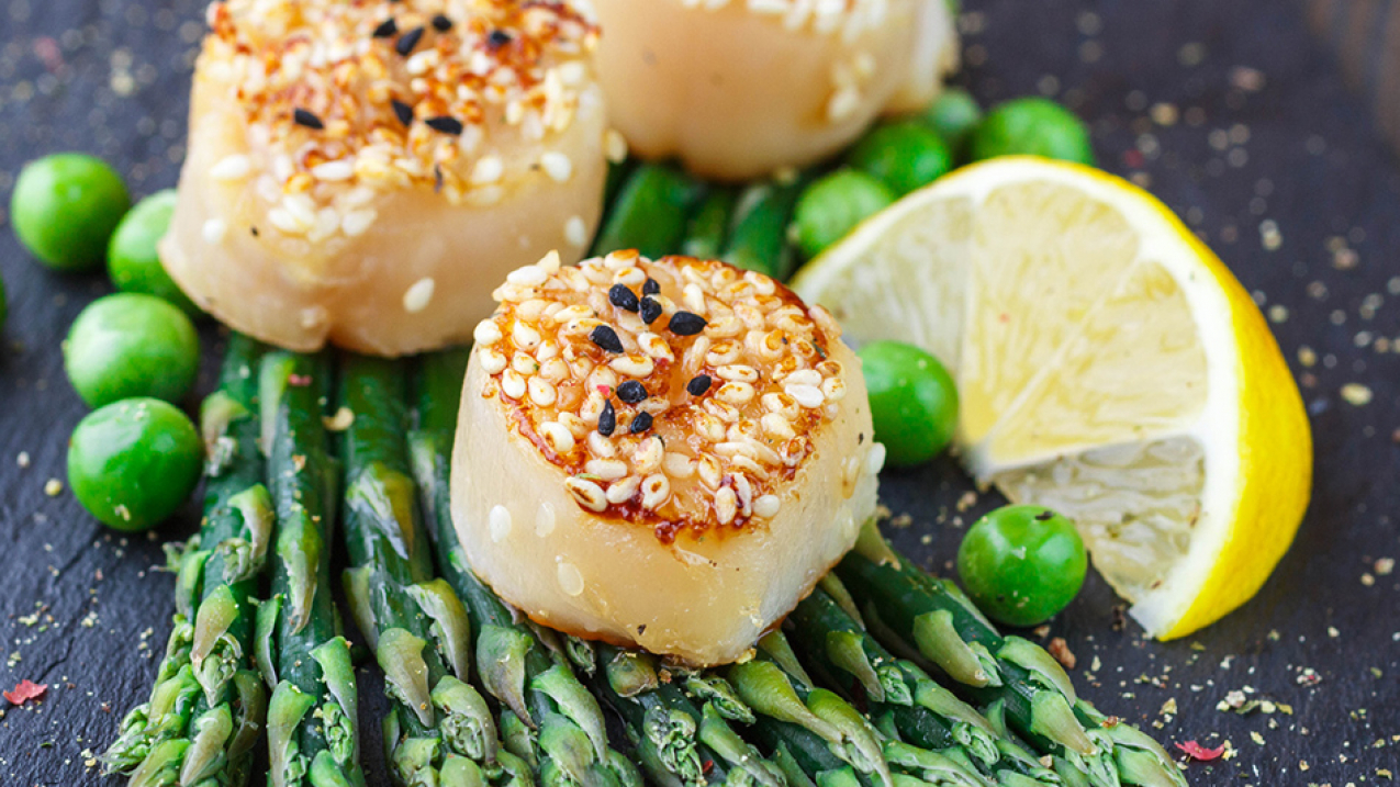 Fried scallops with sesame seeds, asparagus and lemon.