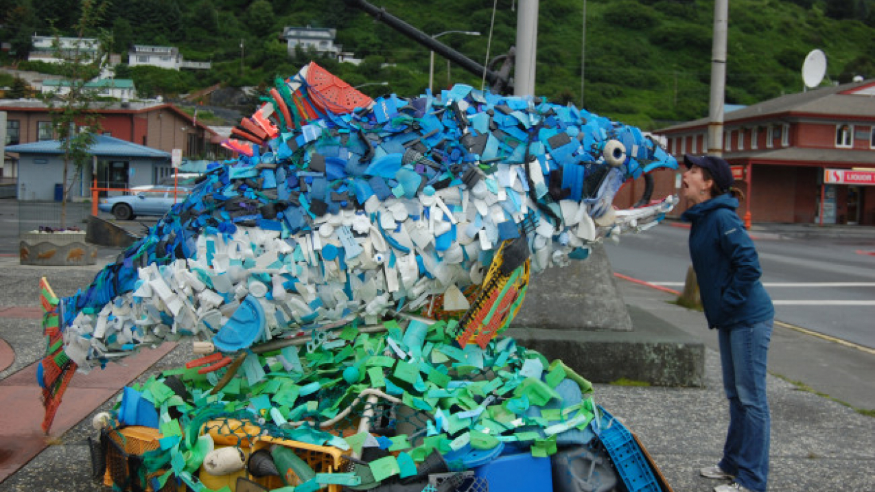 Teacher at Sea Rosalind Echols poses with a salmon sculpted out of marine debris in Kodiak, AK. 