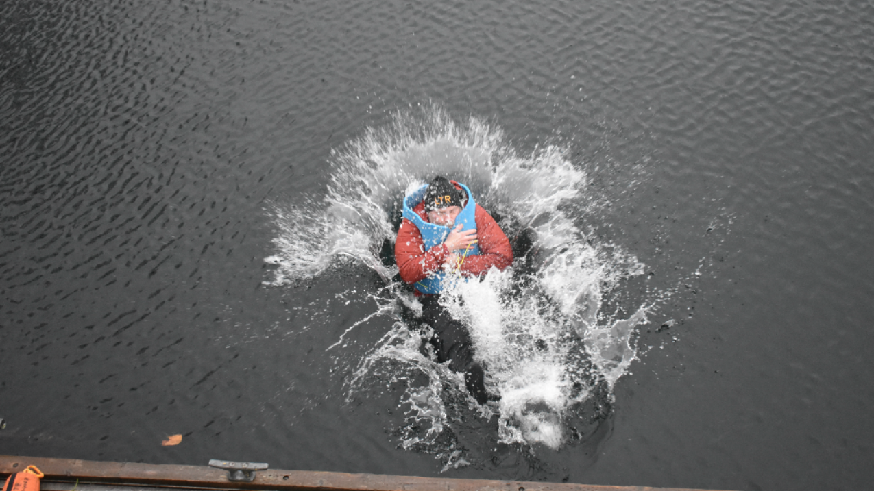 A NOAA scientist practices Arctic survival skills in cold waters of Seattle's Lake Washington, December 2019. Exercises like these teach trainees to focus on survival and the future. Trainees practiced cold-water survival swimming techniques and how to get onto a life raft.