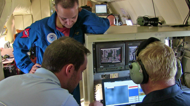 The crew monitors the in-flight Coyote UAS from the piloting station on the P3. (Credit: NOAA/AOML)
