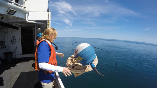Teacher at Sea Susan Dee deploys a drifter buoy.