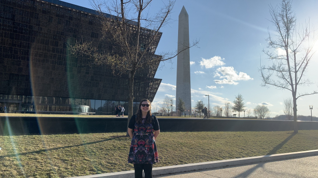Molly Wozniak stands in front of the Washington Monument and the Smithsonian’s National Museum of African American History and Culture while visiting the NOAA Office of Education in person in Washington, D.C. on March 3, 2020.
