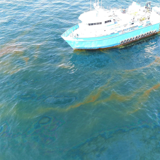 Drone image of R/V Brooks McCall at MC20 site with rising oil and gas at the surface, September 2018, in the Gulf of Mexico. NOAA NCCOS scientists aboard the vessel surveyed the site (September 1–7, 2018) to determine the source, composition, and extent of the oil and gas discharge.
