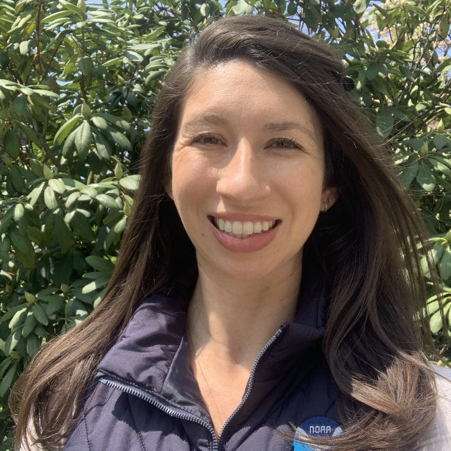 Headshot of Andrea wearing an insulated vest with a NOAA Fisheries Greater Atlantic Region logo on it.