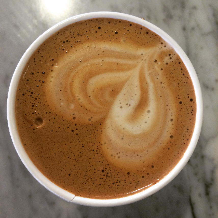 A photograph of a latte with a heart design in the foam. 