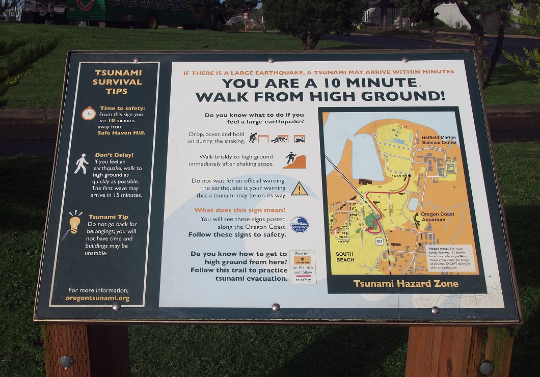 Oregon public sign providing tsunami survival tips and directions to high ground.
