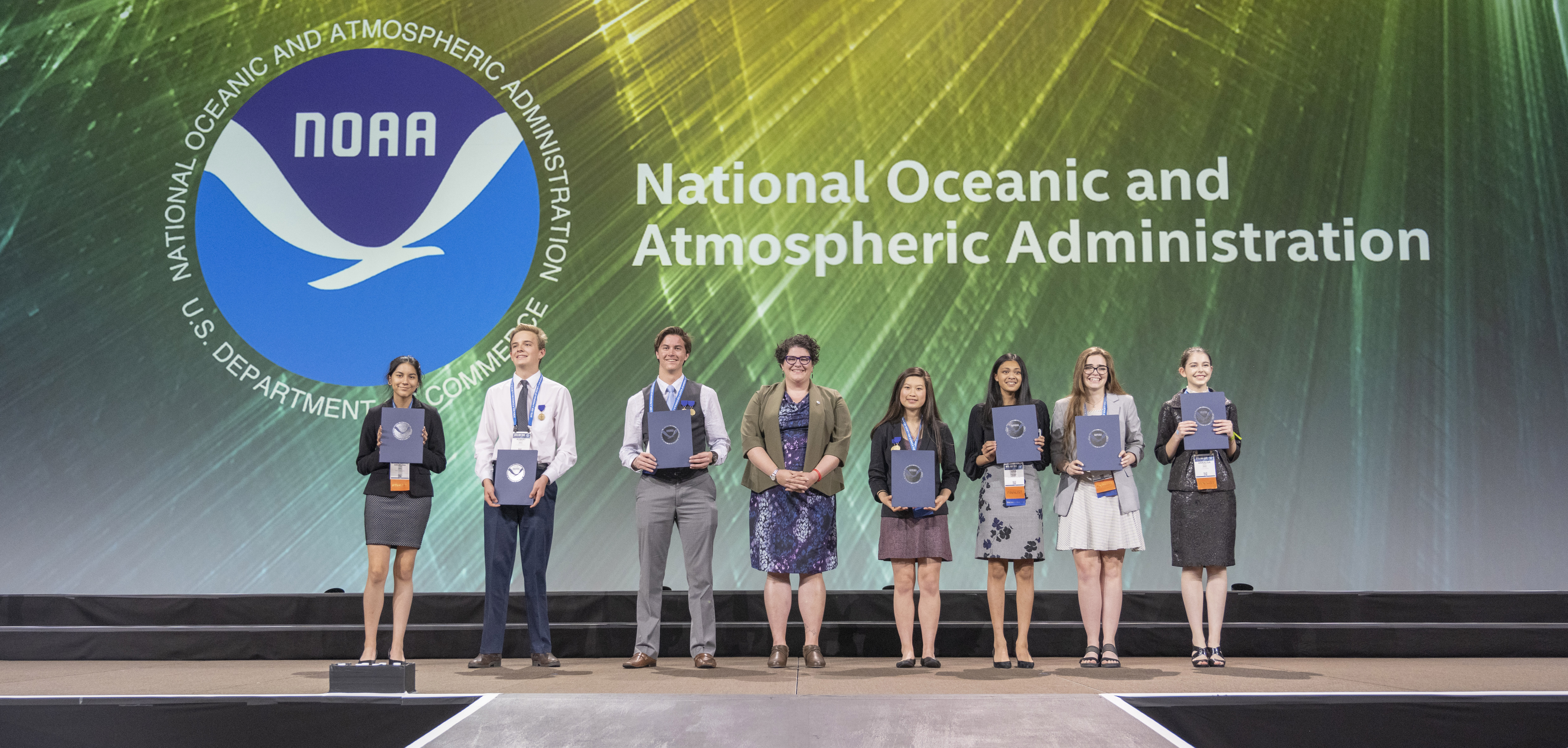 On May 16, 2019, NOAA Education Outreach Specialist, Bekkah Lampe (center), presented the Taking the Pulse of the Planet awards to seven students at the Intel International Science and Engineering Fair in Phoenix, Arizona. 