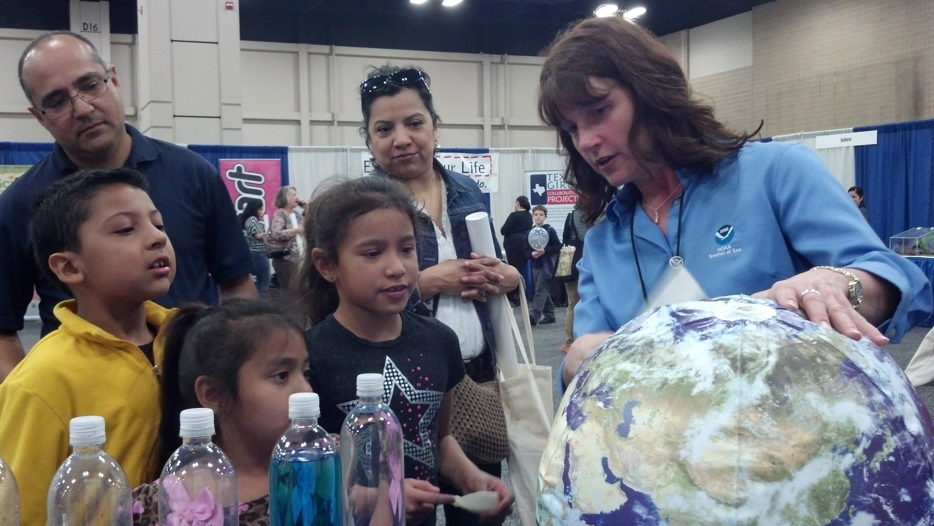 A Teacher at Sea Alum at National Science Teachers Association National Conference in San Antonio in 2013 showing off earth science activities to three children and two adults. 