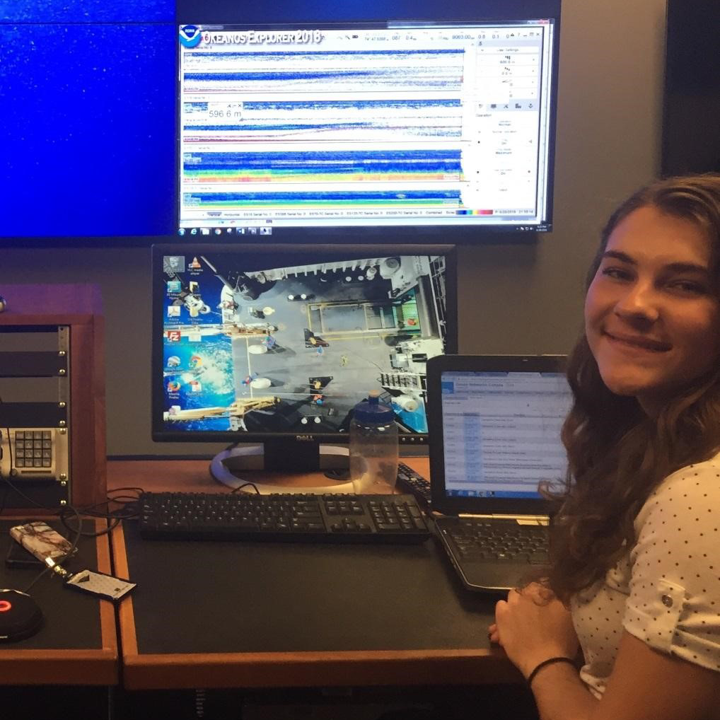 Gina Selig, an Educational Partnership Program Undergraduate Scholar, is interning this summer with the NOAA Office of Exploration and Research, where she is investigating the latitudinal and vertical distributions of an open ocean sea cucumber in the central Pacific using exploratory data. In this photo from June 2018, Gina is virtually participating in the NOAA Ship Okeanos Explorer Windows to the Deep expedition from the Exploration Command Center in Silver Spring, Maryland. Gina is helping to log