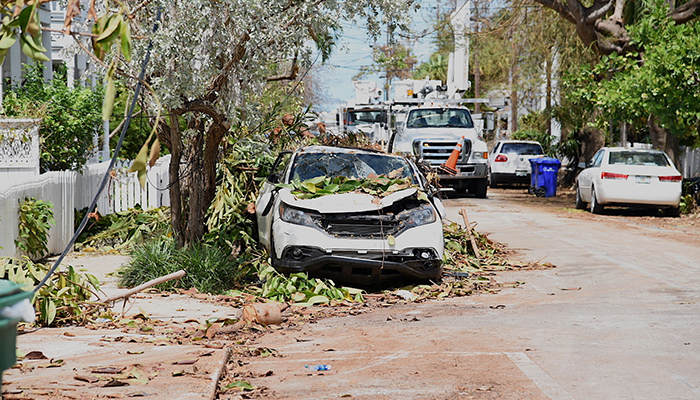 A street in downtown Key West, Florida is impassable as damaged cars sit in the street and utility truck work to restore power after Hurricane Irma, Sept. 15, 2017. 