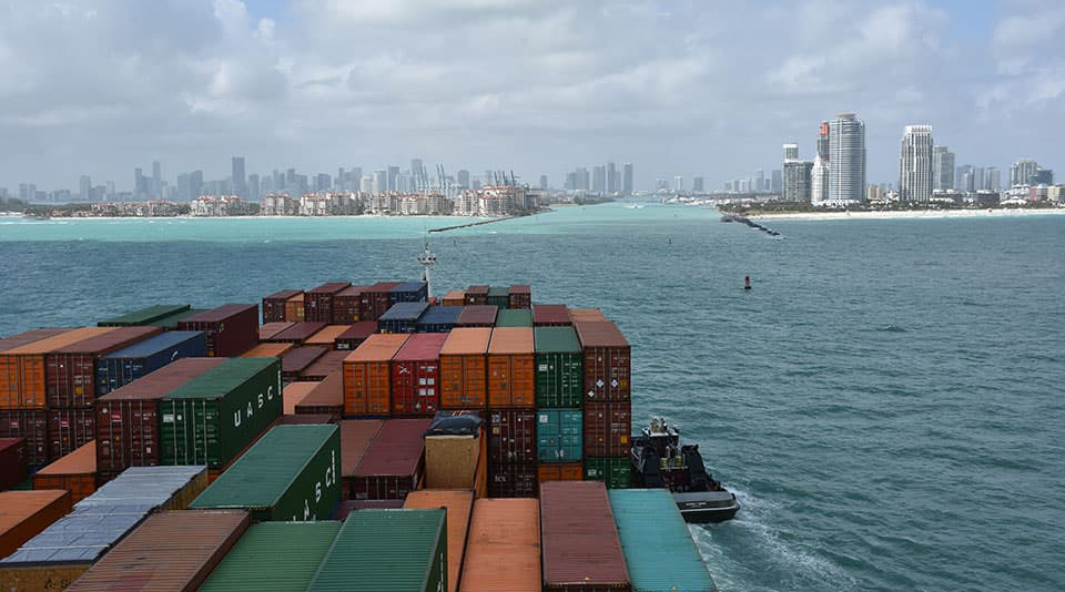 A container ship enters the shipping channel at PortMiami.