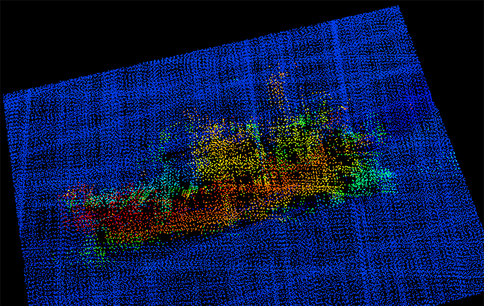 A 3-D image from NOAA Ship Fairweather multi-beam sonar. The profile of the F/V Destination is clearly visible, including the bulbous bow to the right, the forward house and mast, equipment (likely crab pots) stacked amidships, the deck crane aft, and the skeg and rudder. 
