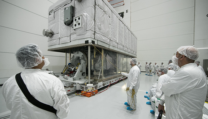 Inside the clean room at Astrotech, technicians operate machinery that lifts the satellite’s protective slowly, so they  can complete a close inspection of GOES-S to make sure it was not damaged during its road trip. 