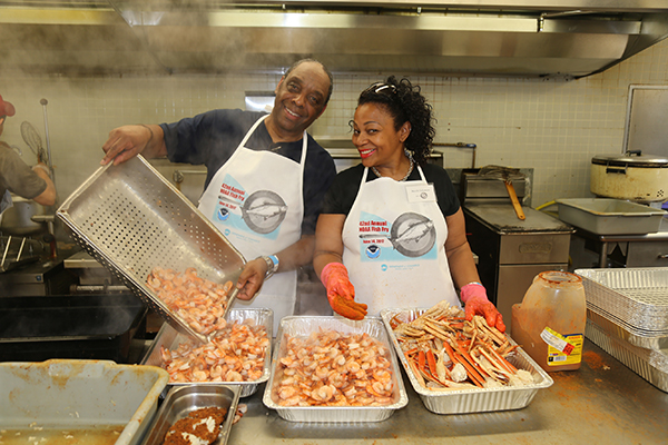 Albert “Benjie” Spencer, a NOAA employee with the National Weather Service, and Nicole Solomon prepare the ever-popular spiced shrimp and snow crab legs.