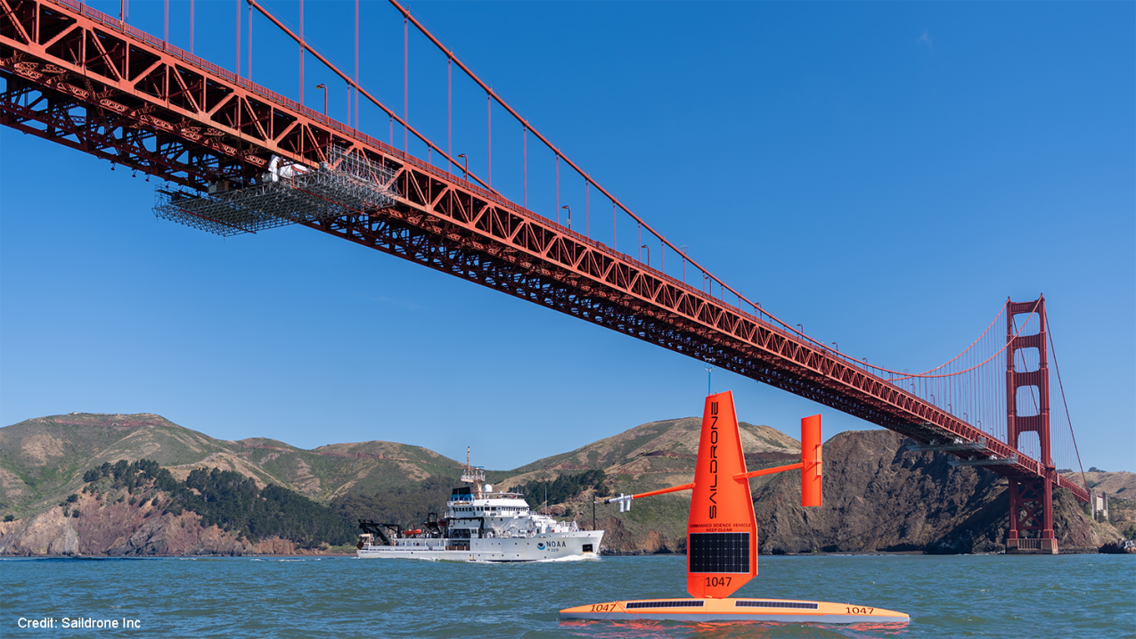 A Saildrone collects data beneath the Golden Gate Bridge alongside a NOAA research vessel. 
