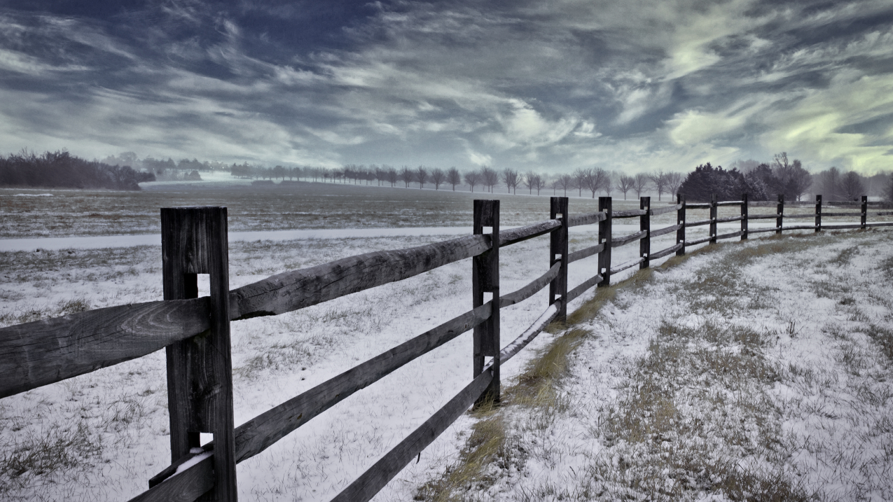 Photo showing snow on a fence and in a field in Kansas.