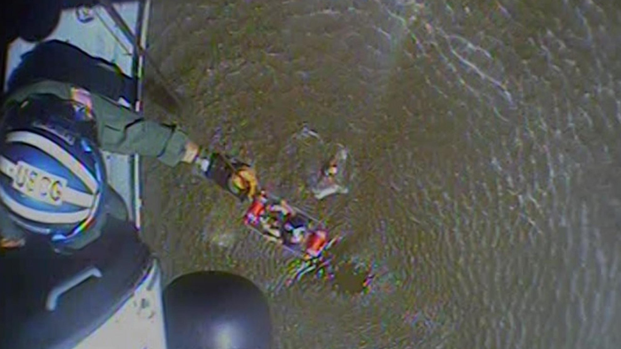 A still photo taken from a video of a Coast Guard Air Station New Orleans MH-60 Jayhawk aircrew rescuing a boater from a capsized vessel near Slidell, Louisiana, on September 18, 2022. The boaters and their dog were safely rescued and transported to a nearby marina. 