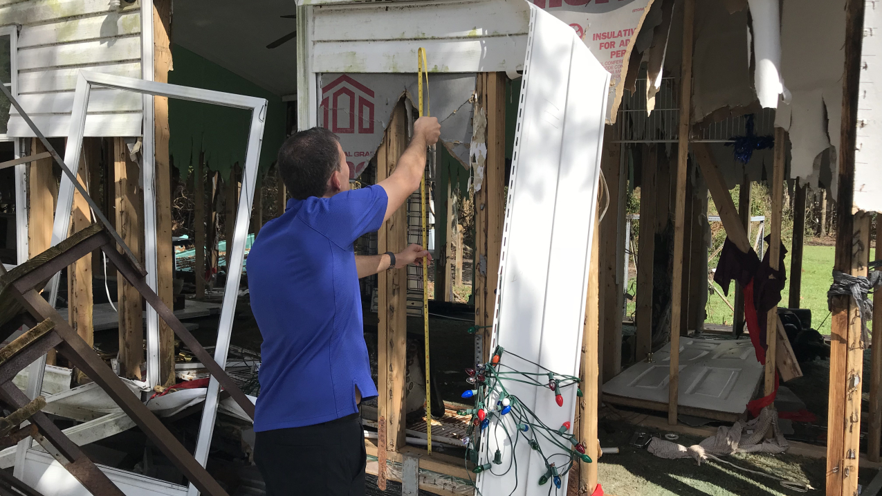 Photo of Jamie Rhome, now acting director of NOAA’s National Hurricane Center, measuring the impact of storm surge from Hurricane Florence at a heavily damaged home in New Bern, North Carolina on September 26, 2018.