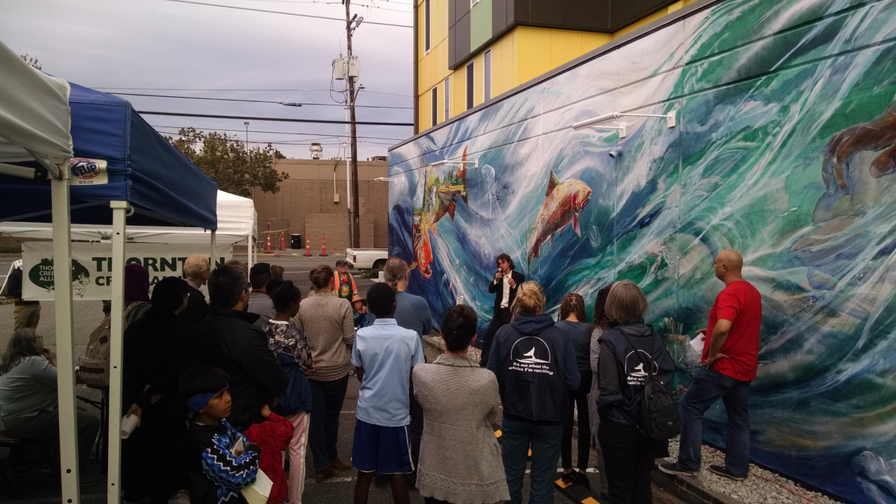 Artist Esteban Camacho Steffensen addresses community members during an event to celebrate Seattle’s new salmon mural.