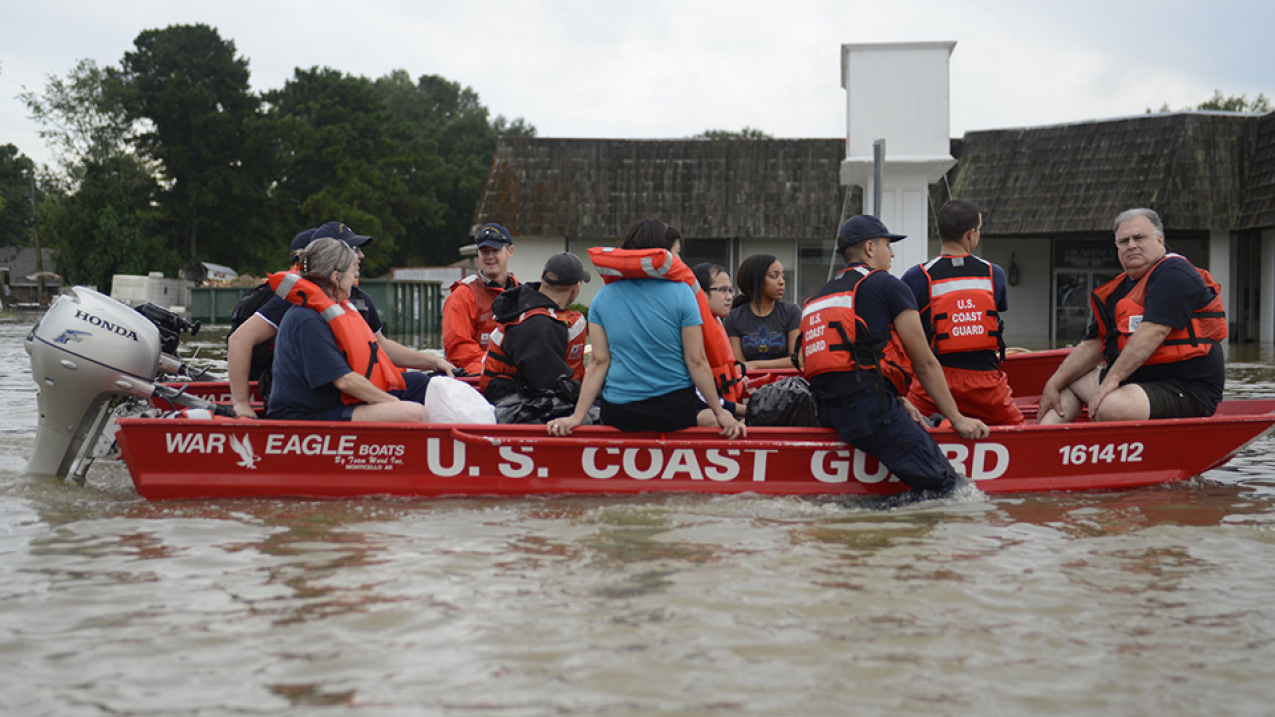 U.S. Coast Guard members rescue locals from flood water on their flat-bottom boats in Baton Rouge, Louisiana, Aug. 14, 2016. 