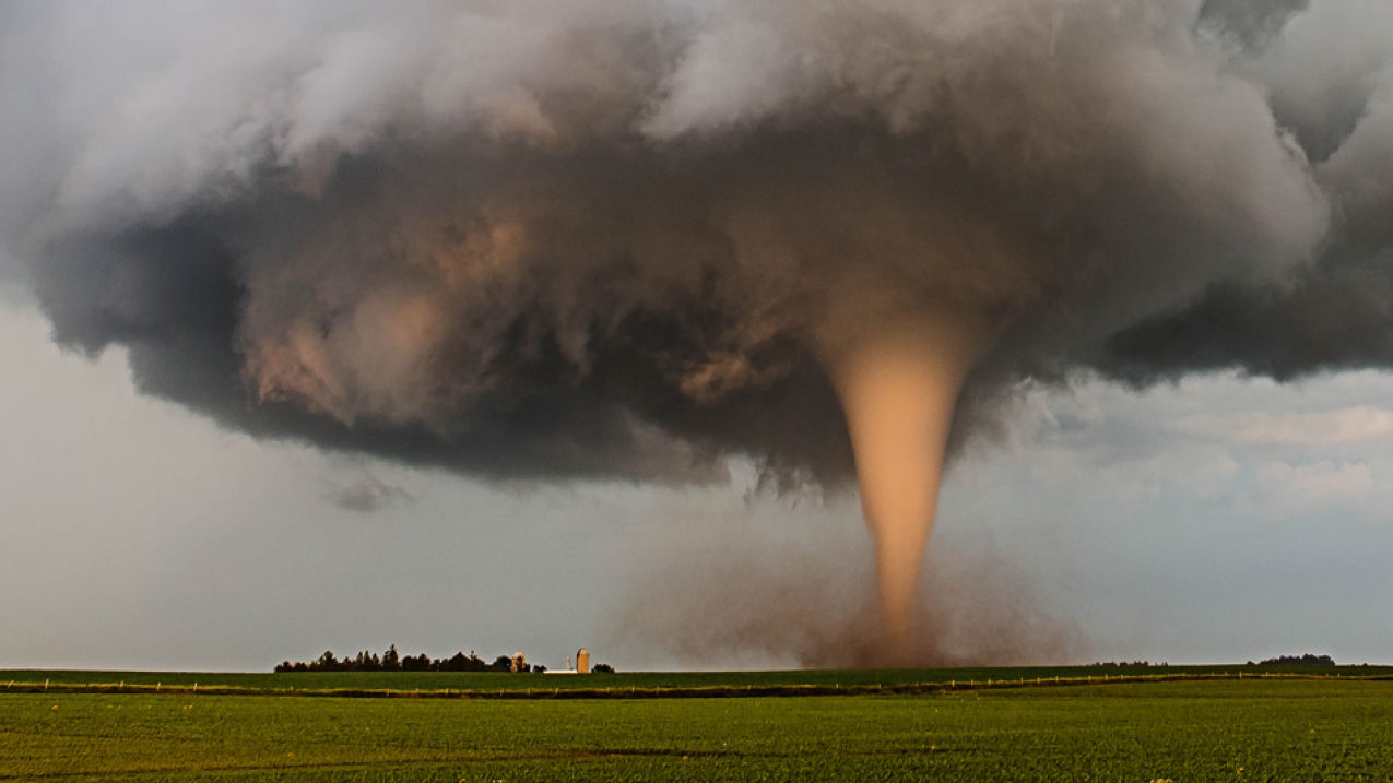 A tornado churns up dust in the sunset light near Traer, Iowa by Brad Goddard, Orion, IL