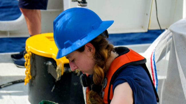 Survey Technician Sophia Tigges is seen here removing barnacles from oceanographic sensors that were attached to a moored buoy.
