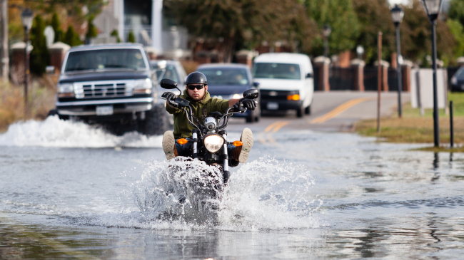 Person on motorcycle in flooded street in Norfolk, Virginia