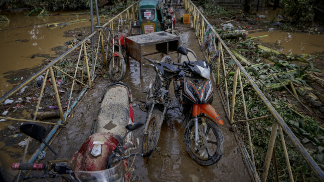 Flooded motorcycles are seen parked on a bridge in a village hit by Super Typhoon Noru on September 26, 2022, in San Miguel, Bulacan province, Philippines.