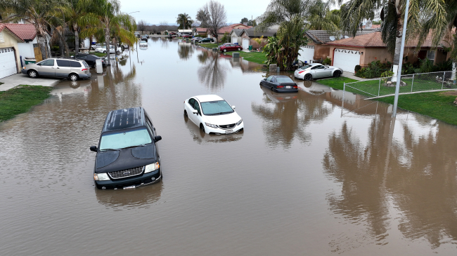 Cars in floodwaters on January 11, 2023, in Planada, California, after the town was devastated by widespread flooding following a severe atmospheric river event. A series of nine atmospheric rivers dumped a record amount of rain and mountain snow across parts of the western U.S. from late December into mid-January, hitting California particularly hard.