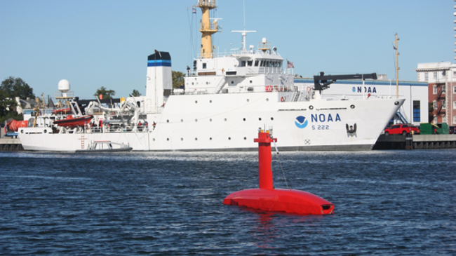 Uncrewed surface vehicle DriX floats near a NOAA ship in Puget Sound, Washington.