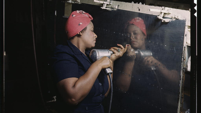 Operating a hand drill at Vultee-Nashville, woman is working on a "Vengeance" dive bomber, Tennessee.