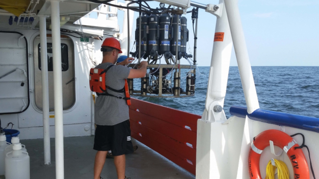 Scientists from Louisiana Universities Marine Consortium deploy a water sensor called a CTD sonde rosette to collect water samples to test for oxygen levels during the 2015 R/V Pelican's shelf wide hypoxia cruise.