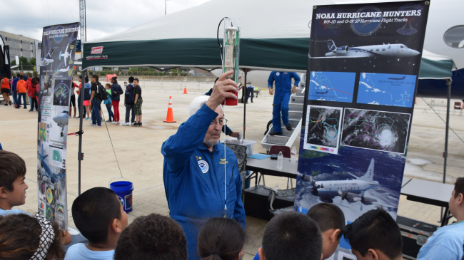 NOAA Aircraft Operations Center Chief of Programs and Projects Dr. Jim McFadden demonstrates the use of a dropwindsonde to students at San Antonio International Airport during the 2016 Hurricane Awareness Tour. 