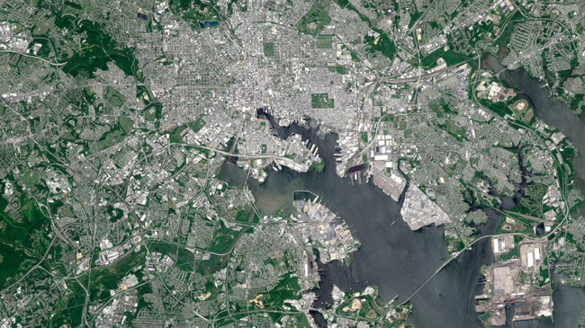 This satellite image of Baltimore shows the dramatic contrast between large areas of vegetation to the more densely developed neighborhoods at the city’s core. The NOAA-funded Heat Island research quantified strikingly different temperatures from block to block on one of the hottest days of summer 2018. 