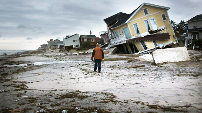 Man walking on beach surveying the damage to Rockaway Beach, Queens, New York, from Post-tropical Cyclone Sandy in 2012. The Climate Resilience Toolkit provides information that can help people prepare for future extreme events and climate change.