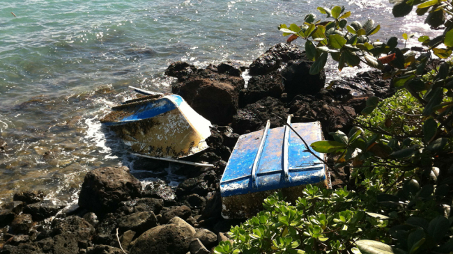 A small vessel on the rocky shoreline in Kahana Bay, Oahu, Hawaii.