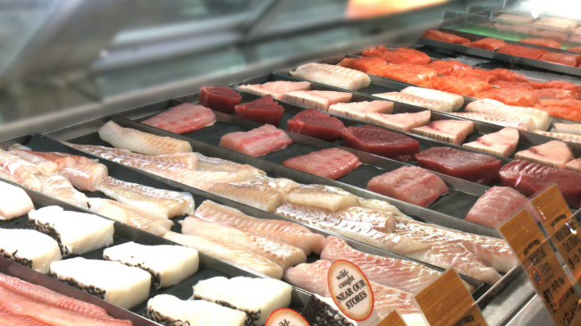 A grocery store counter displaying fish fillets.