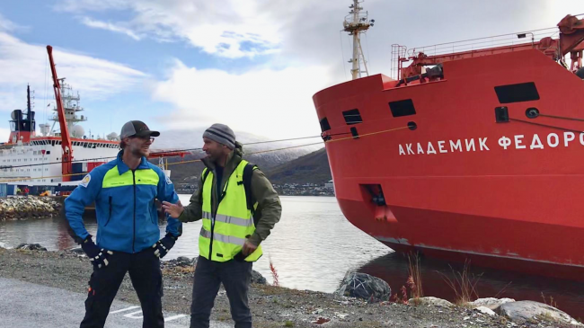 NOAA/CIRES researcher Matthew Shupe, co-lead of MOSAiC talks with Thomas Krumpen, from the Alfred Wegener Institute on Sept. 19, 2019 in Tromso, Norway, as the mission prepares to launch. The German icebreaker Polarstern, which will be locked in ice for 13 months, is to the left. The support ship Russian Federov, right, will return to Norway in October, while Polarstern will remain frozen in the ice until next fall. Photo: Sara Morris, NOAA/CIRES