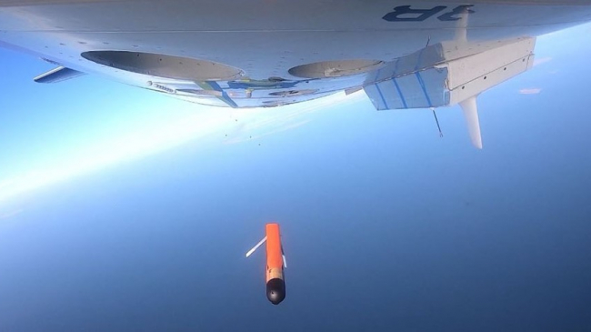 View of the underside of the NOAA Hurricane Hunter plane as the Altius-600 uncrewed aircraft (research drone) is deployed high over a field during flight tests on January 15, 2021.