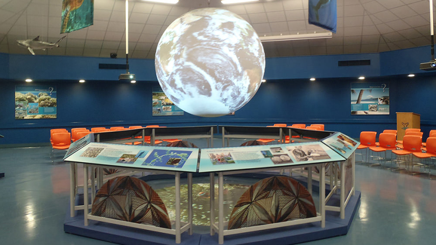 Inside of the Tauese P.F. Sunia Ocean Center with Science on a Sphere, a six-foot animated globe, featured prominently surrounded by ocean exhibits.