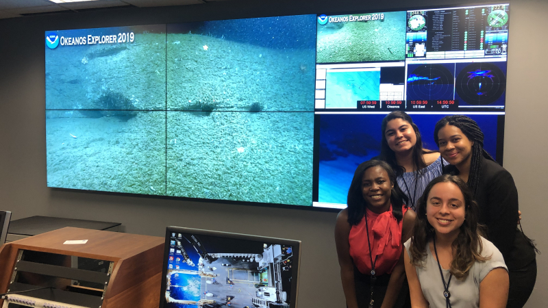Educational Partnership Program with Minority Serving Institutions scholars from the class of 2019 view ocean exploration footage from NOAA Ship Okeanos Explorer during scholar orientation at NOAA headquarters in Silver Spring, Maryland. Top row: Jezella Peraza, Elyse Bonner Bottom row: JaNia Dunbar, Paola Santiago