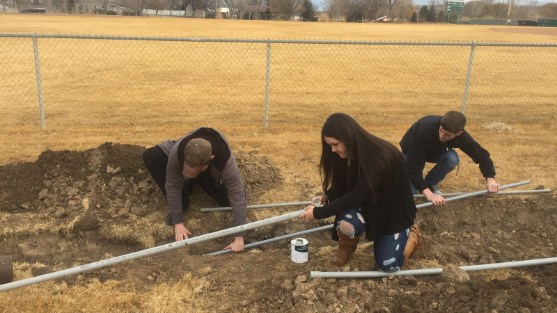 Students Sam Moore, Jocy Trevizo, and Justin Hanning lay conduit for the Delta High School Solar Array.
