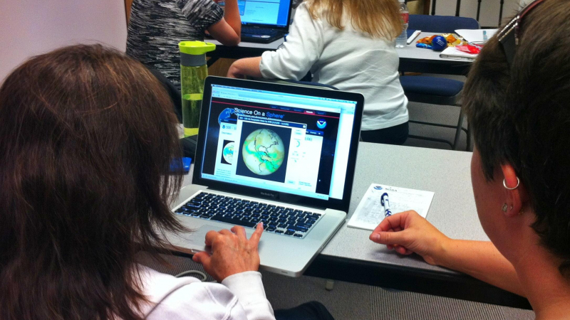 Teachers attending a Science On a Sphere (SOS) workshop work together to develop educational materials from the resources available on the SOS website.