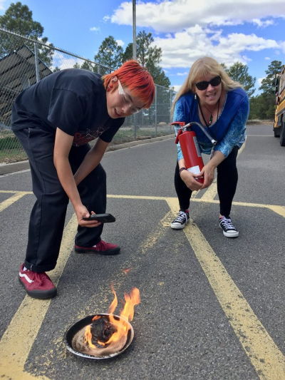 Flagstaff, Arizona, middle school teacher and NOAA Planet Steward Jillian Worssam stands at the ready while her chemistry student demonstrates a “carbon snake” (a controlled experiment that shows a chemical change to matter) for his chemistry final.