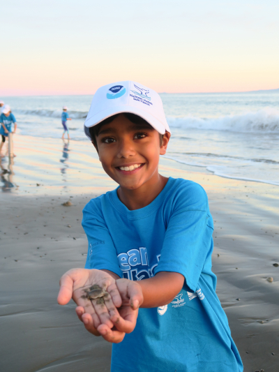 Dillon M., a student at Adams Elementary School in California, shows off a sand crab he found while monitoring a local Santa Barbara beach. As part of NOAA’s Ocean Guardian School program, Adams Elementary students work locally to better understand and protect the ocean. Last year, these students systematically counted the number of Pacific mole crabs in an area of the shoreline, using these numbers as an indicator of beach health through the Long-term Monitoring Program and Experiential Training for