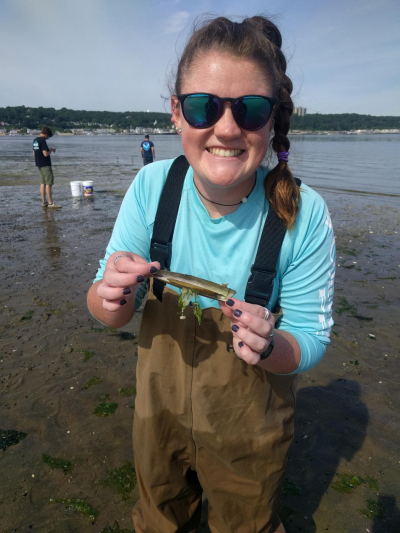 Grace O’Malley, a 2018 NOAA Hollings scholar, is holding a razor clam in Sandy Hook Bay in June 2019. During the summer of 2019, O’Malley interned at the James J. Howard Marine Science Laboratory in Sandy Hook, New Jersey.